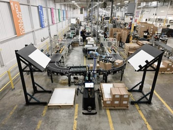 A custom-made Rapid Series Palletizer cobot system with conveyors to fit with the two existing production lines to take over the repetitive tasks of lifting and arranging boxes.